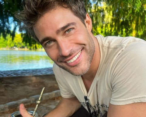 Rodrigo Guirao smiling wide at the camera while sitting in a park.